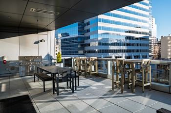 Outdoor terrace overlooking director park, with a fireplace feature and grilling station